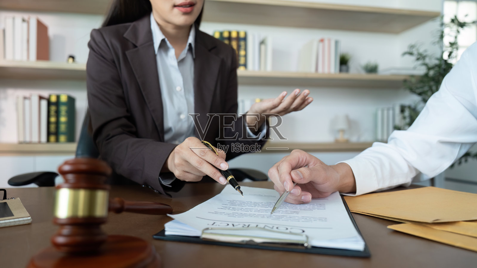 法律讨论。律师向客户解释合同细节。照片摄影图片