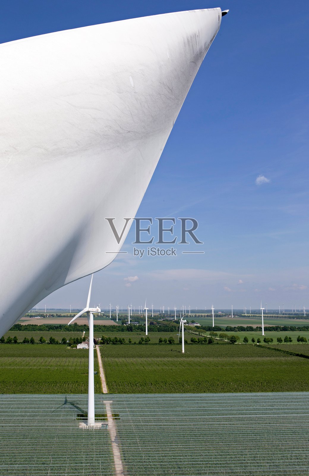 荷兰果园中的防雹网航拍照片。风力涡轮机的导管。照片摄影图片