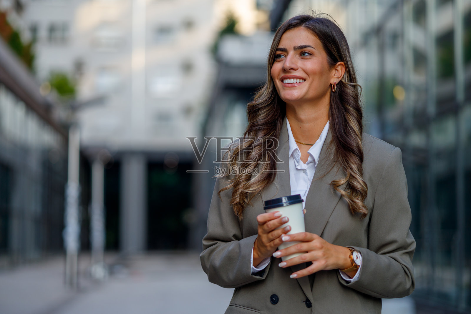 职业女性在白天走近企业外部时喝咖啡照片摄影图片