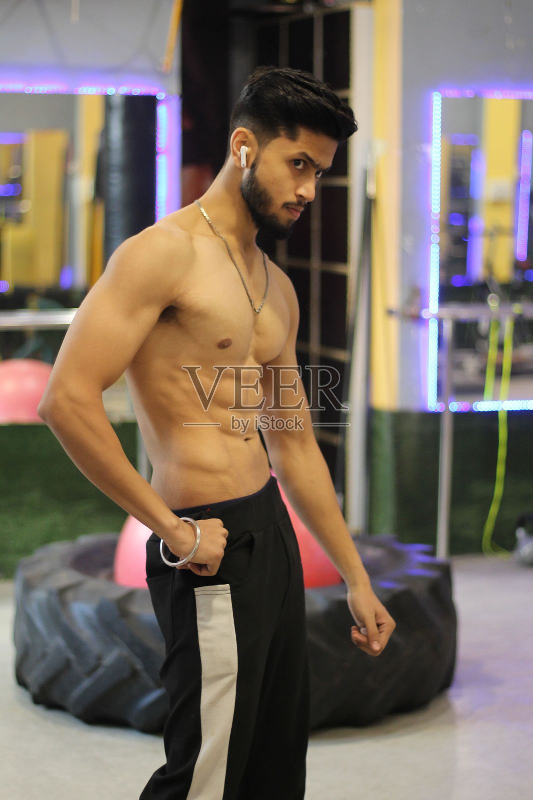 健身房里肌肉发达的印度男性在展示二头肌照片摄影图片