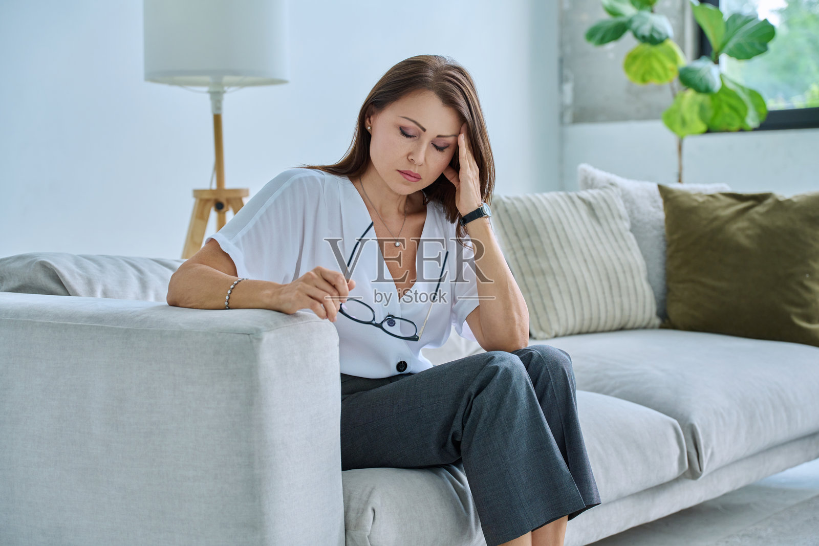 成熟的悲伤女性在家中经历压力、心理和身体的痛苦照片摄影图片