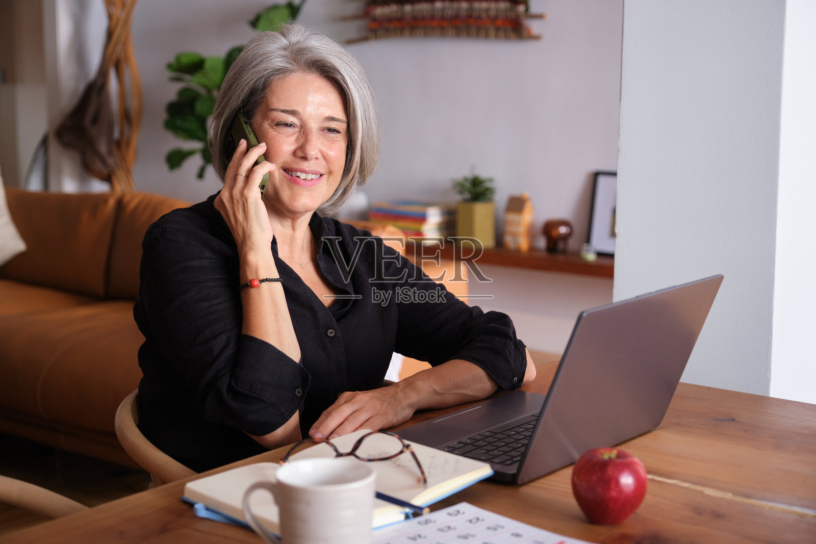 在家工作的资深女商人正在打电话照片摄影图片