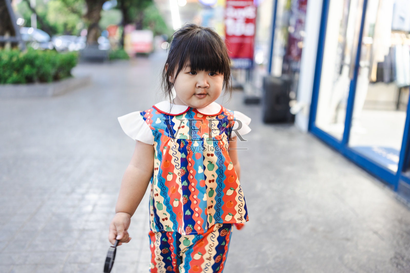 一个可爱的亚洲小女孩拿着放大镜，四处走动探索周围的环境；一个好奇的小男孩用放大镜探索大自然。照片摄影图片