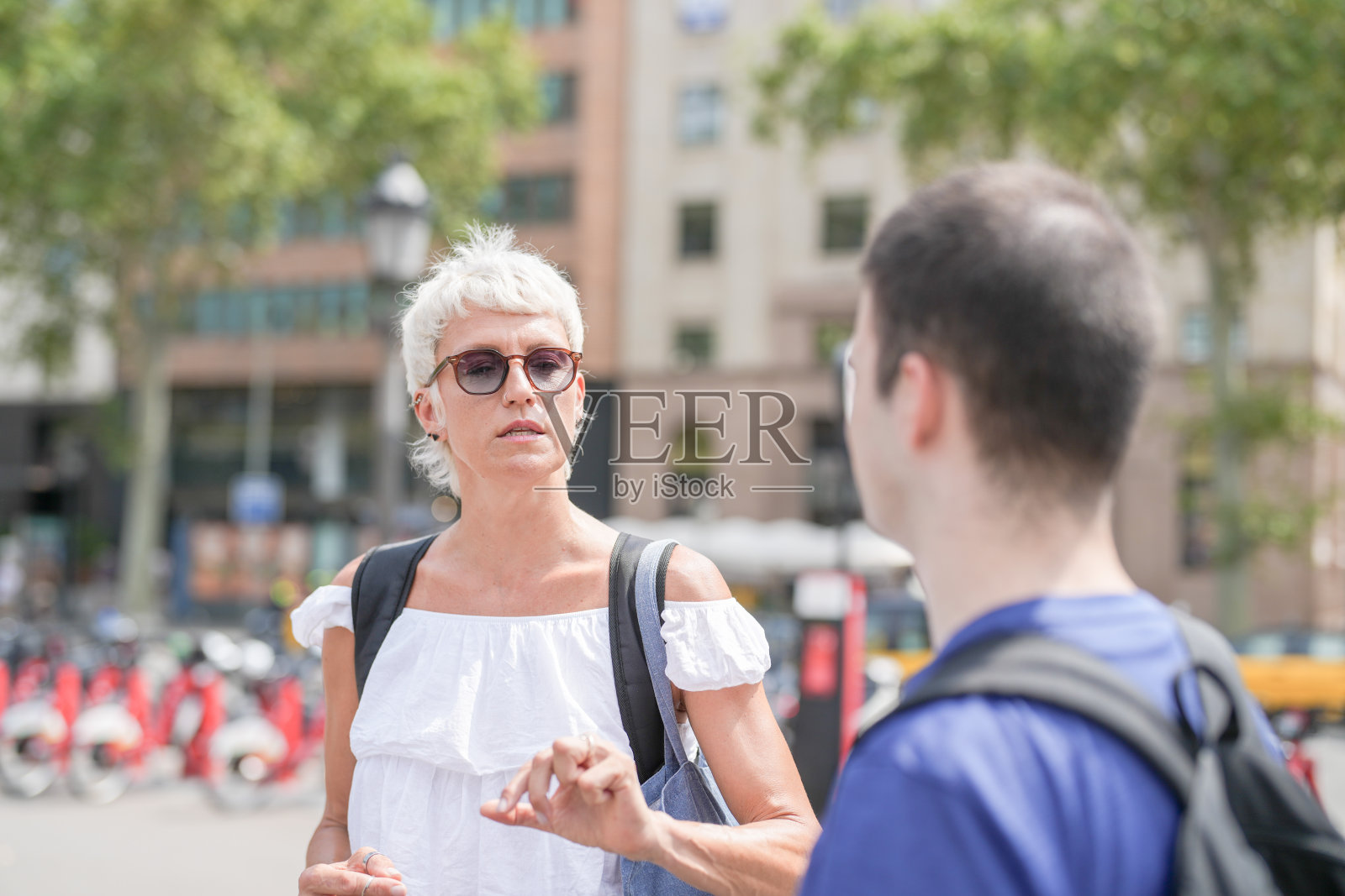 一名女性和一名男性在街角交谈照片摄影图片
