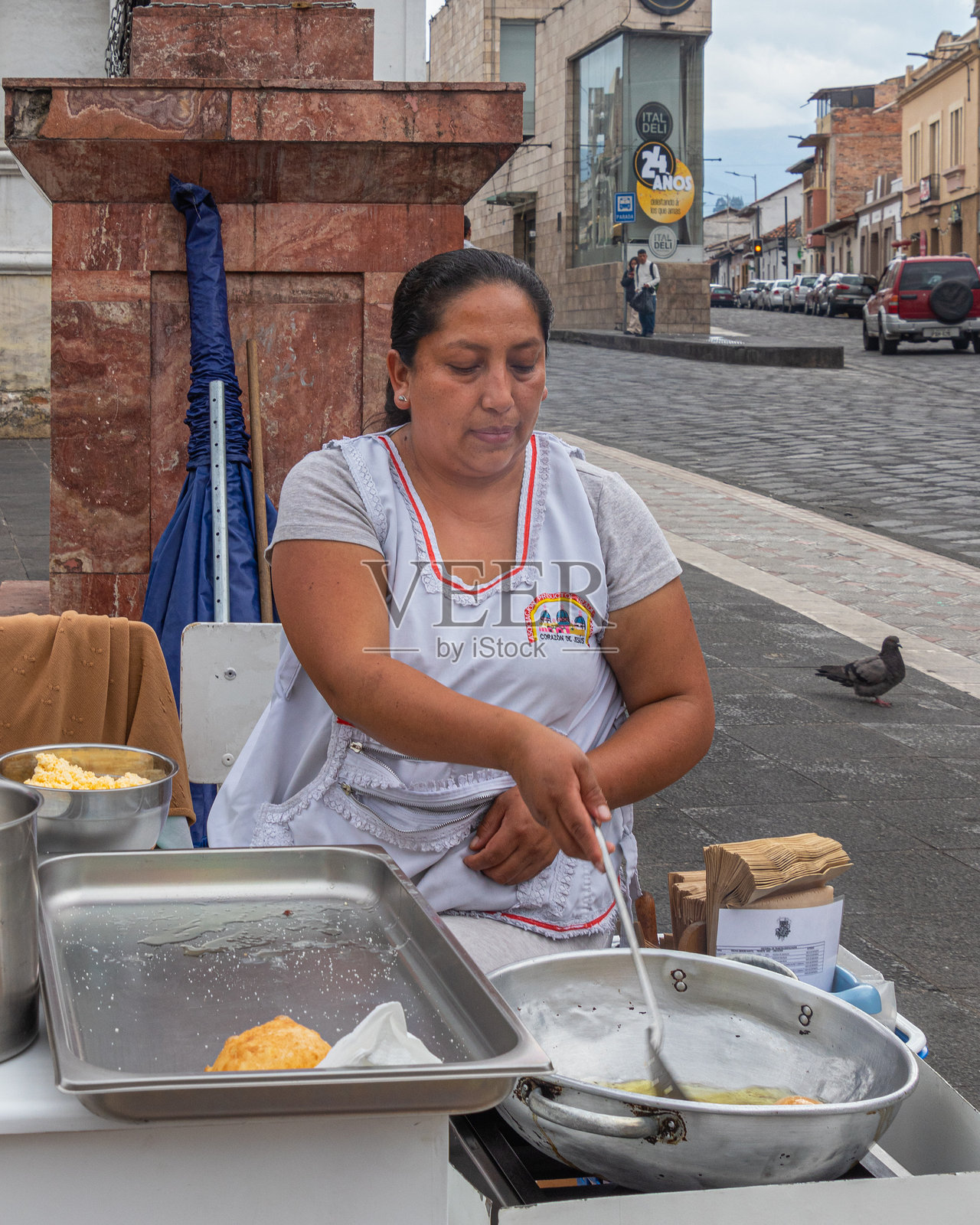 一位女性在厄瓜多尔准备和出售风饼，街头小吃。照片摄影图片