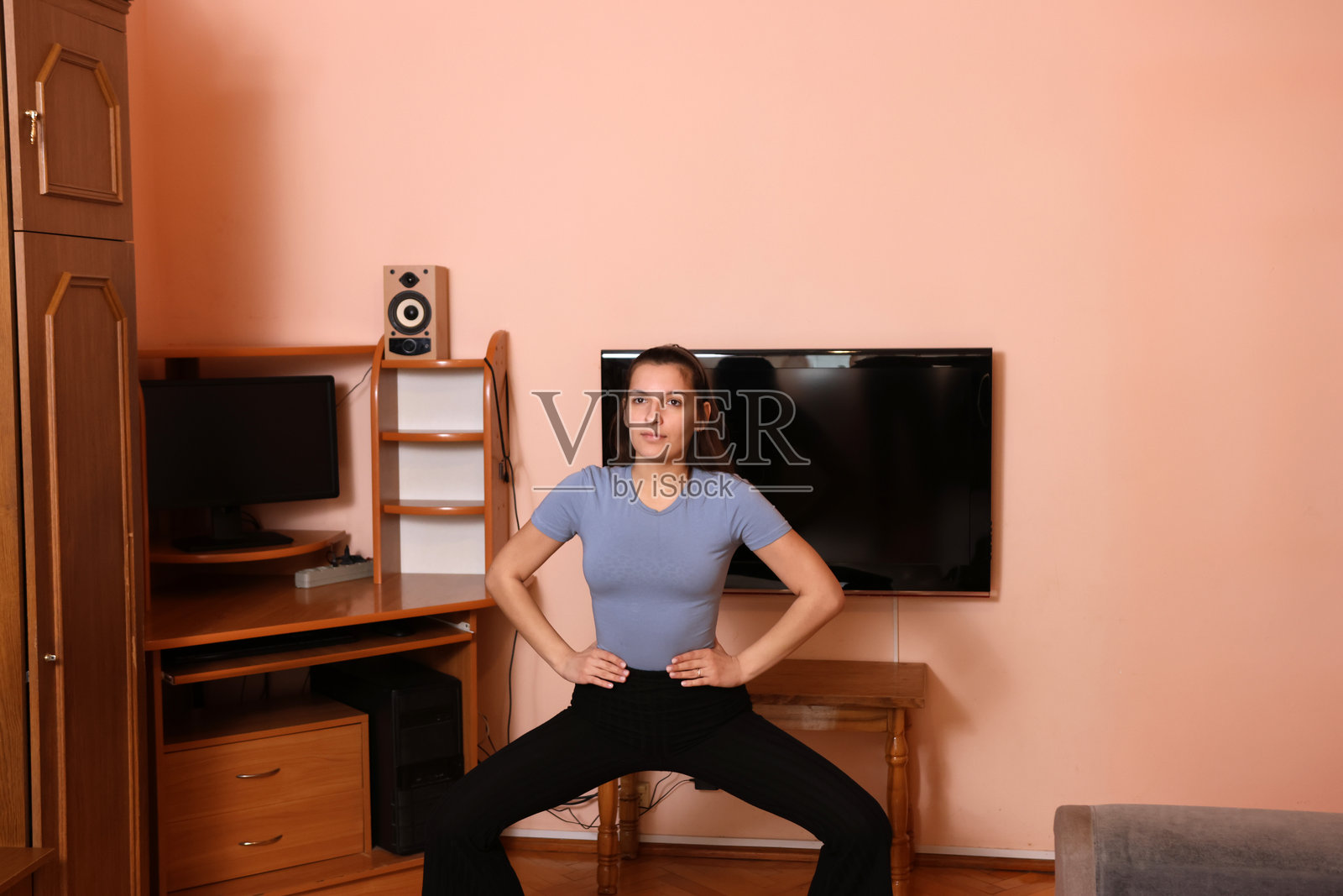 美丽的女孩在家锻炼。家庭健身。照片摄影图片