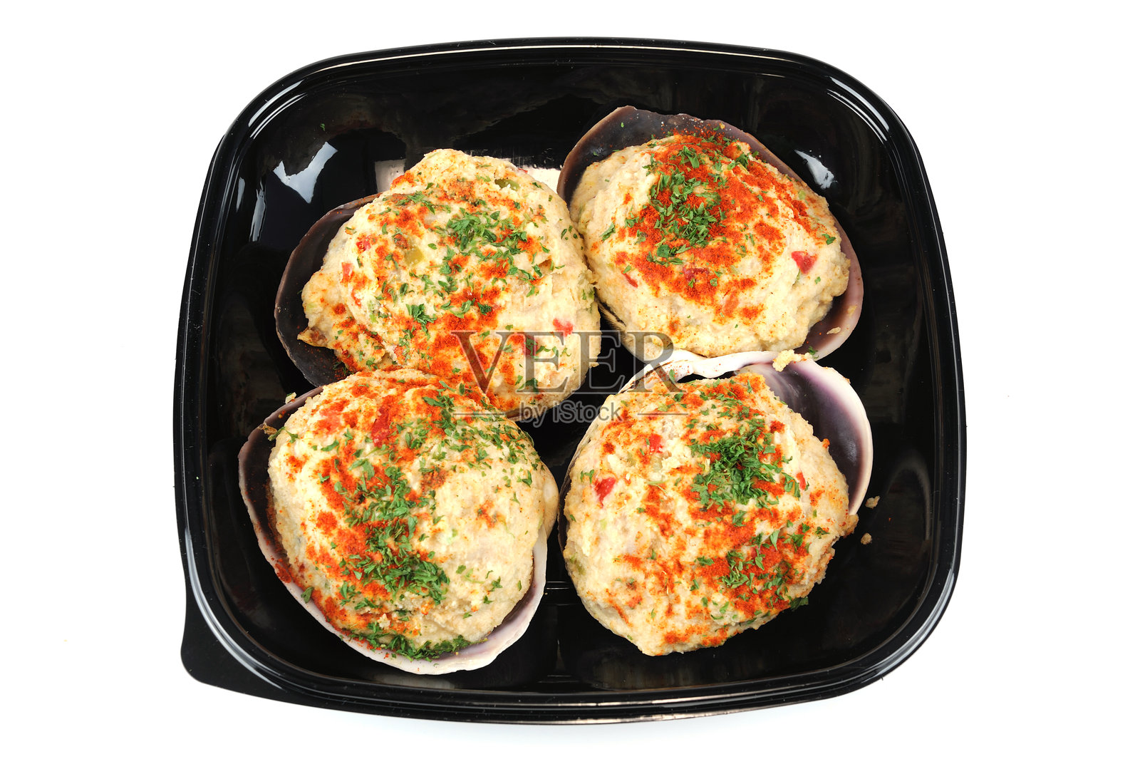 新鲜烹饪的填馅蛤蜊放在黑色托盘中照片摄影图片