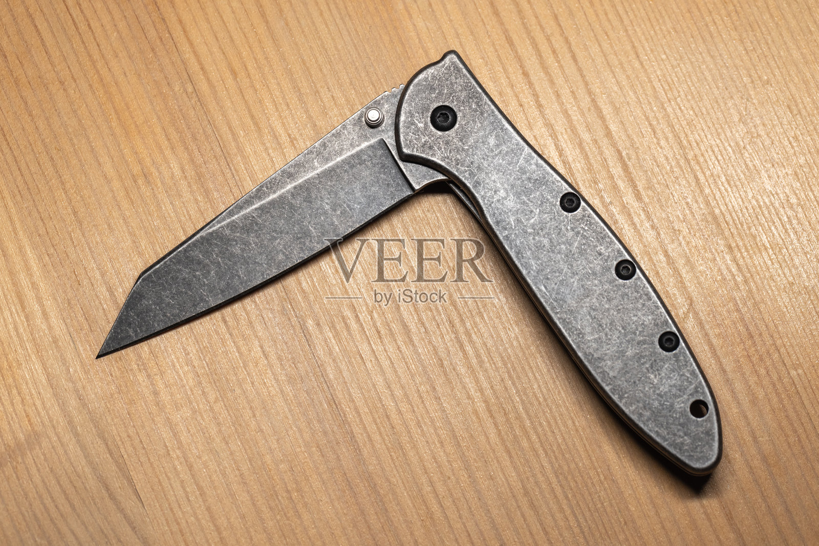 现代灰色钢制折叠刀的详细视图，半开状态，俯视图照片摄影图片