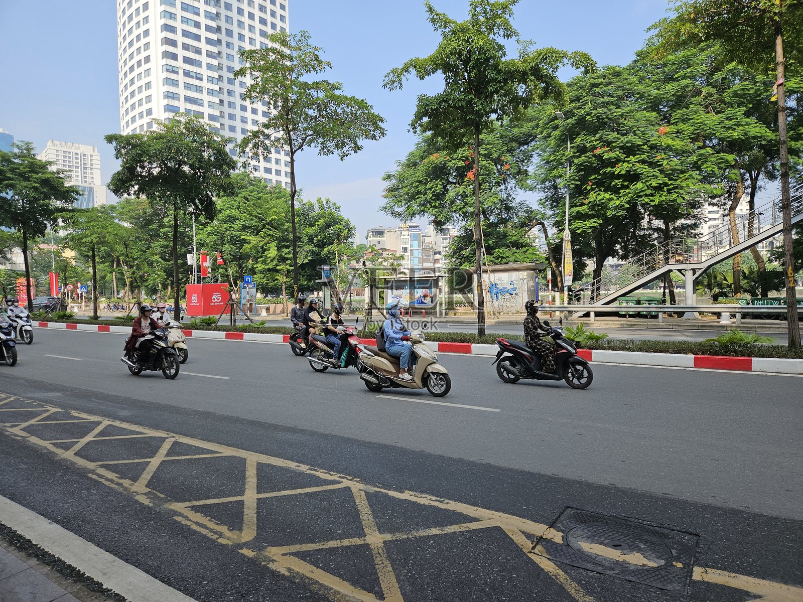 城市交叉口的街景，摩托车和汽车穿行其间。照片摄影图片