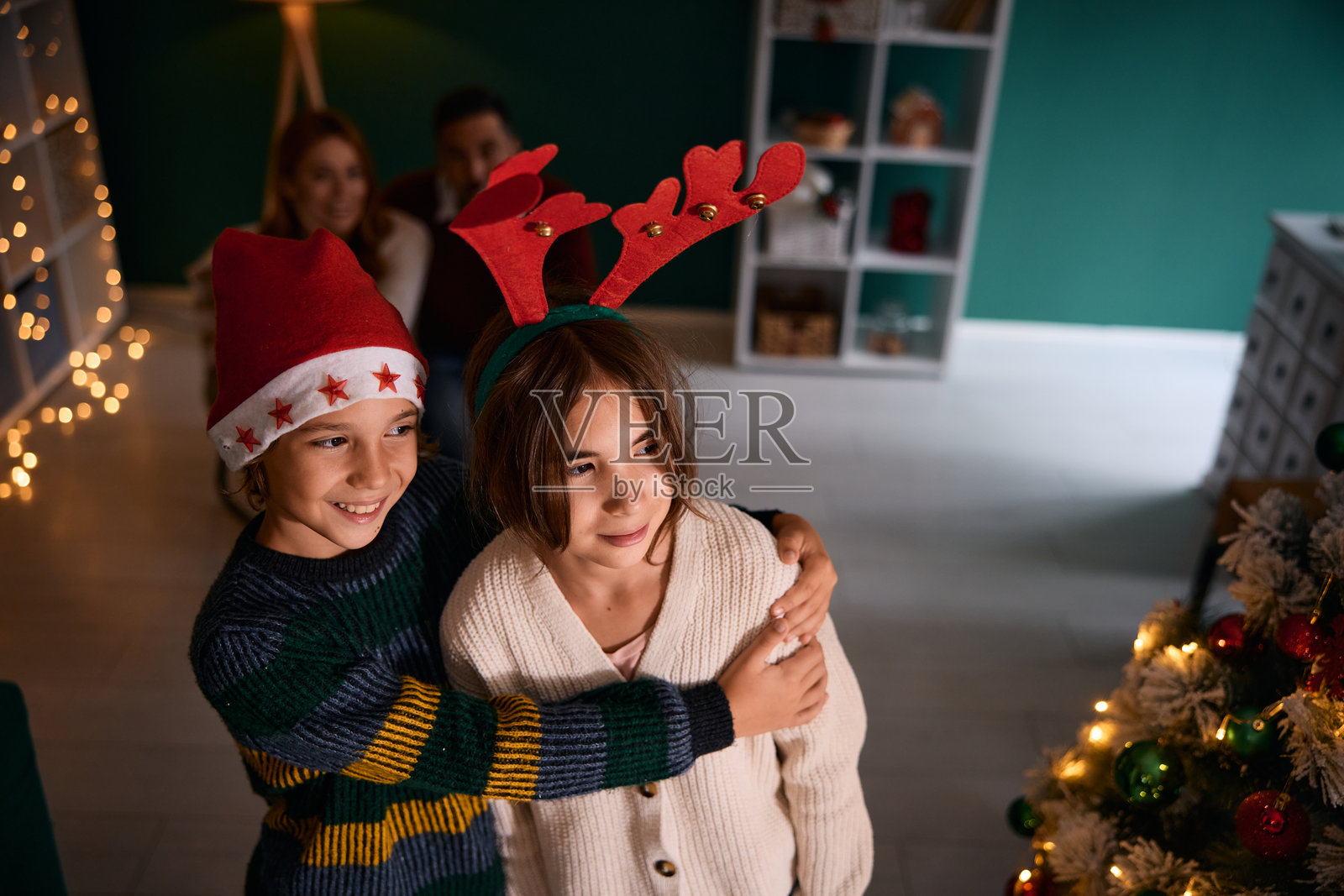 两个快乐的孩子在家中圣诞前夕拥抱在一起照片摄影图片