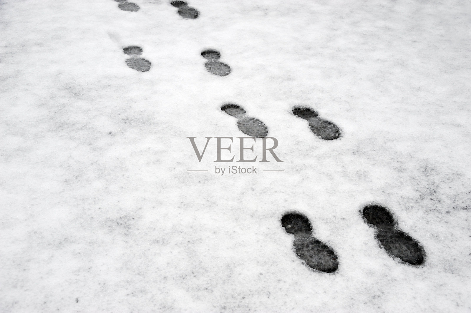 一系列延伸在雪地上的脚印照片摄影图片