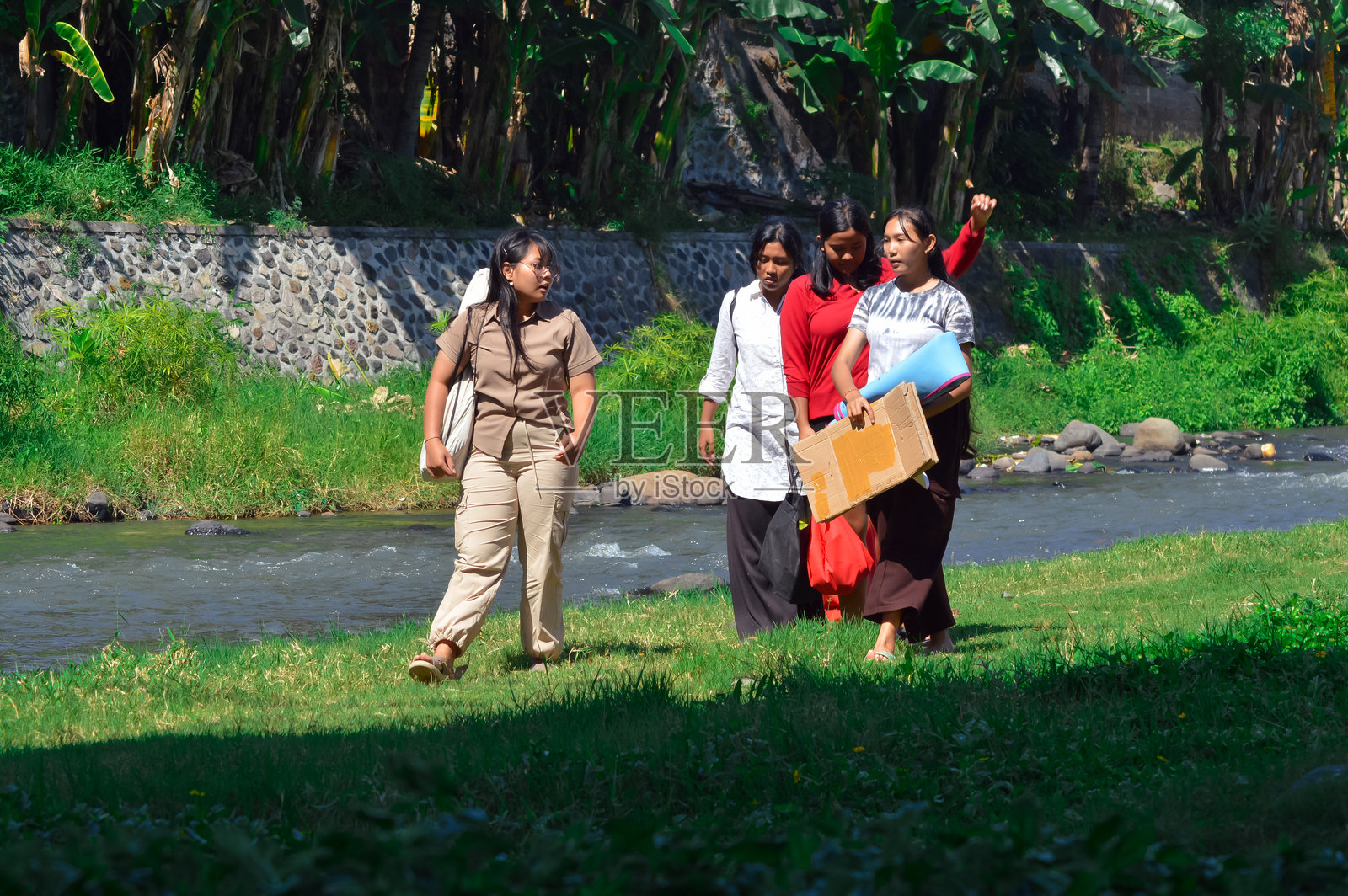 四个女孩从河边露营地回来，看起来很疲惫。照片摄影图片