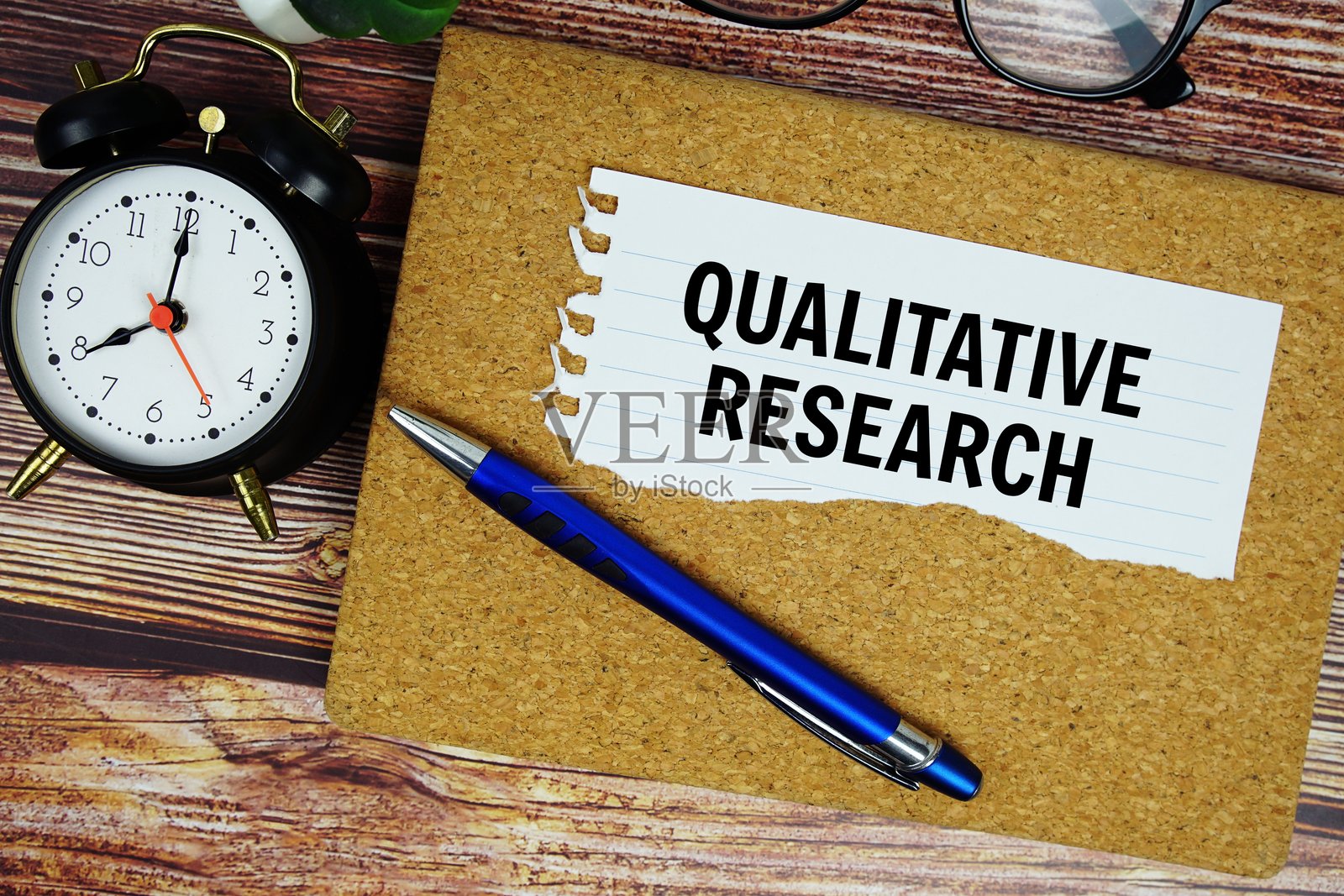 定性研究文本写在撕裂的纸上，俯视角度的闹钟照片摄影图片