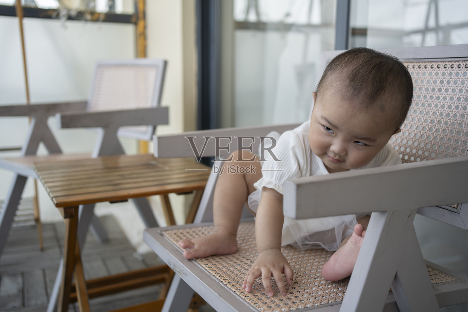 可爱的小宝宝在阳台的椅子上玩耍照片摄影图片