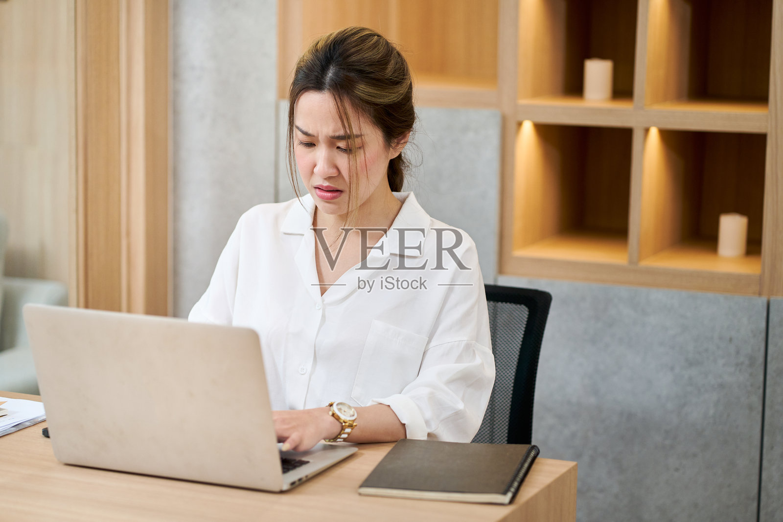 亚洲职场女性认真地看着办公室里的笔记本电脑照片摄影图片