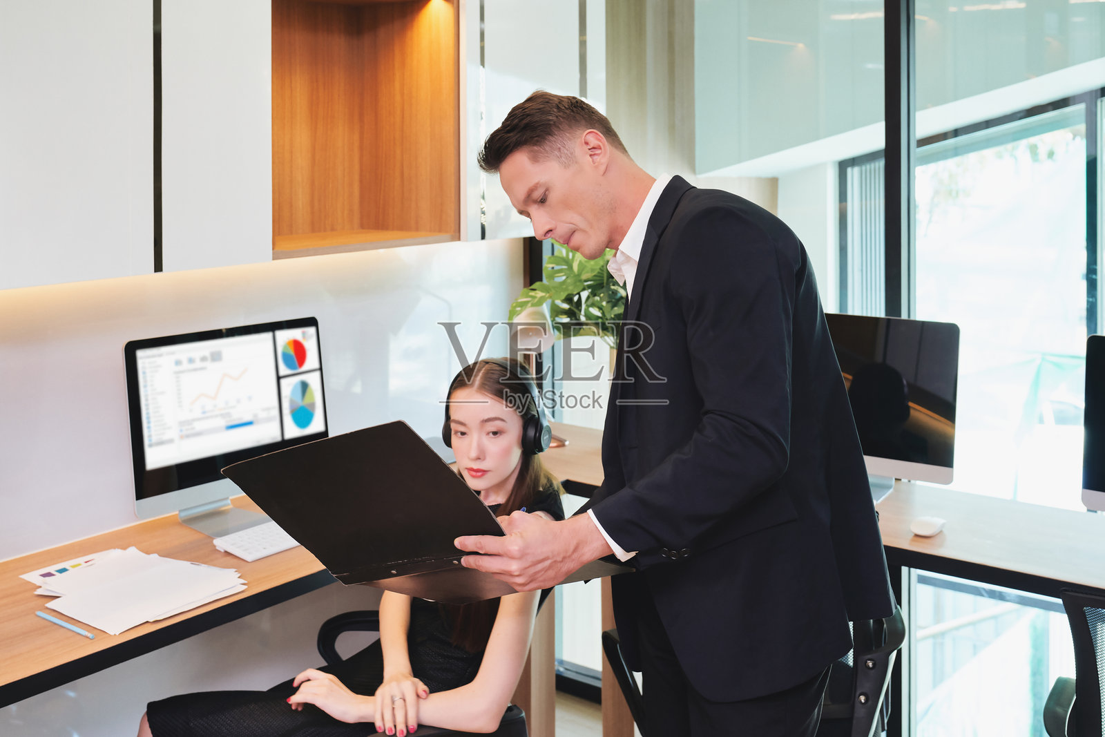 白人男性经理向女性实习生解释工作范围照片摄影图片