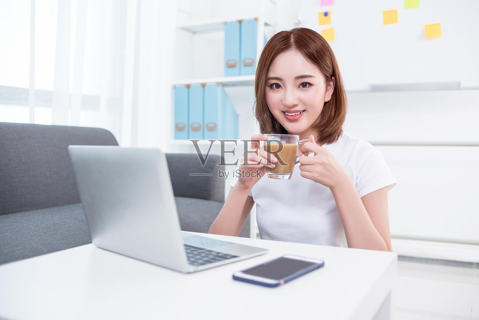 年轻女性悠闲地享受咖啡和笔记本电脑照片摄影图片