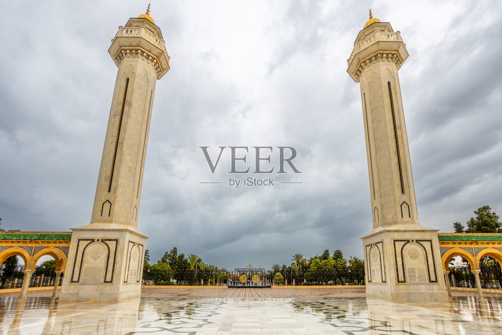 突尼斯莫纳斯提尔哈比布·布尔吉巴陵墓的两座尖塔在阴天中矗立，装饰华丽的大理石庭院。照片摄影图片