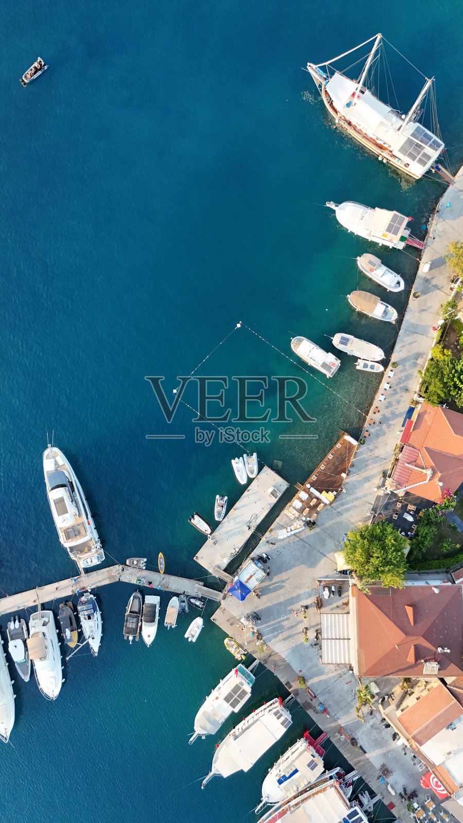 土耳其马尔马里斯的塞利米耶空中视角，蓝色海洋中停着游艇和小船，海岸边有房屋。照片摄影图片