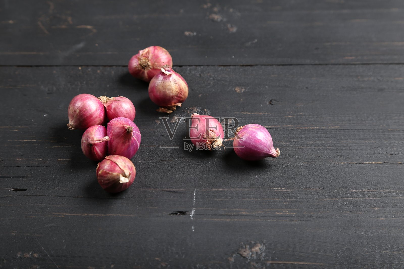 新鲜的带皮小葱和去皮小葱放在深色木质表面上照片摄影图片