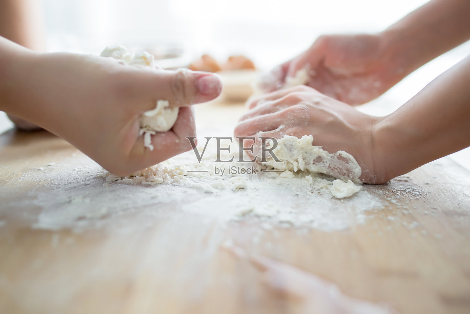 两个人在木桌上用面粉制作面团照片摄影图片