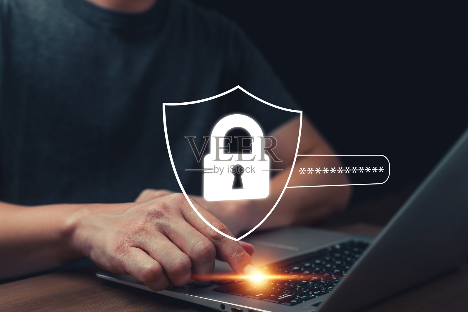 特写镜头显示双手在笔记本电脑上打字，叠加数字盾牌和锁图标，代表网络安全、密码保护、在线隐私和数字世界中的数据安全。照片摄影图片