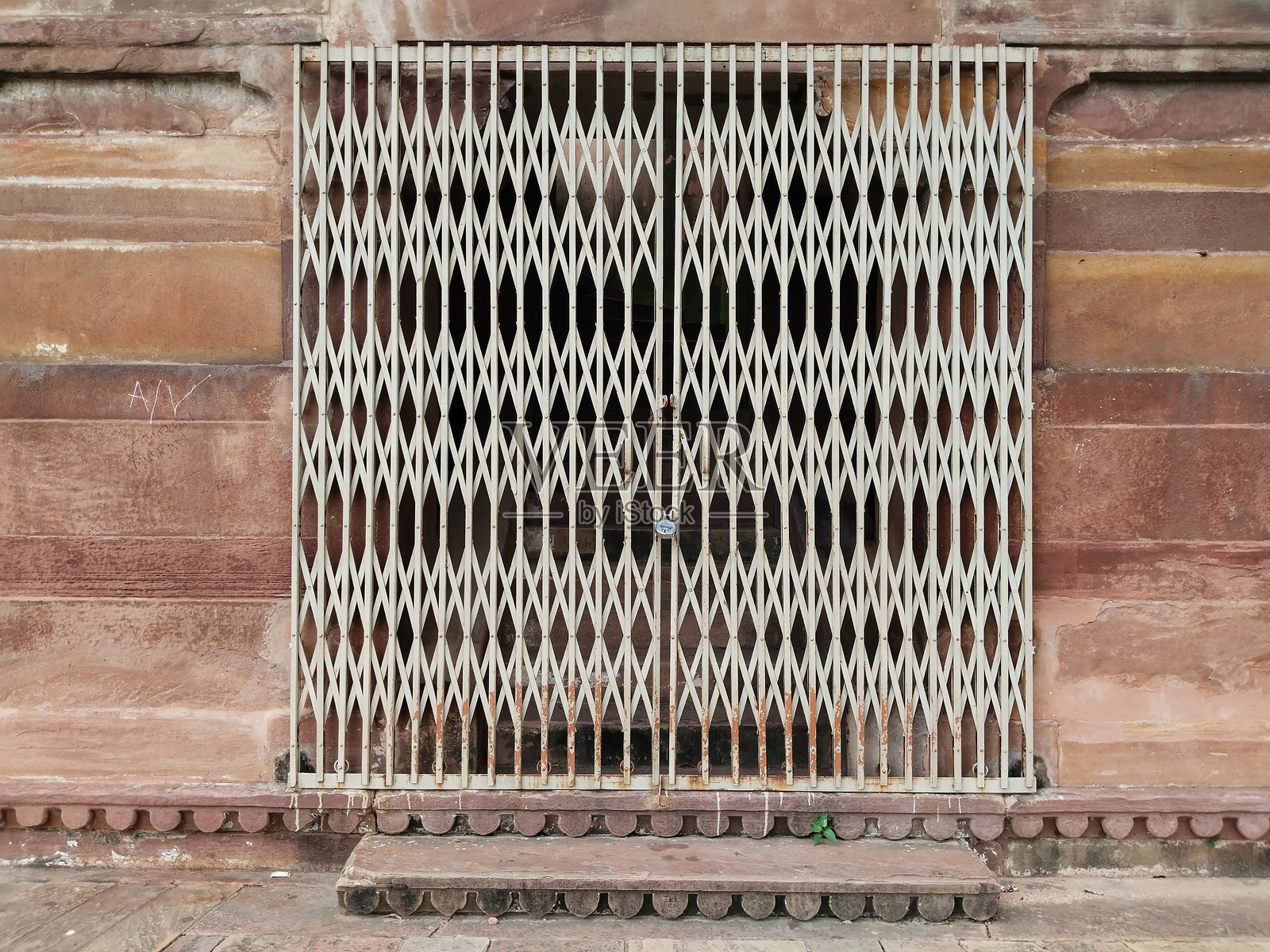 乡村风格的石屋入口，配有金属通道门，传统的乡村建筑，滑动的铁门和石墙，复古的乡村住宅门口在自然光照下。照片摄影图片