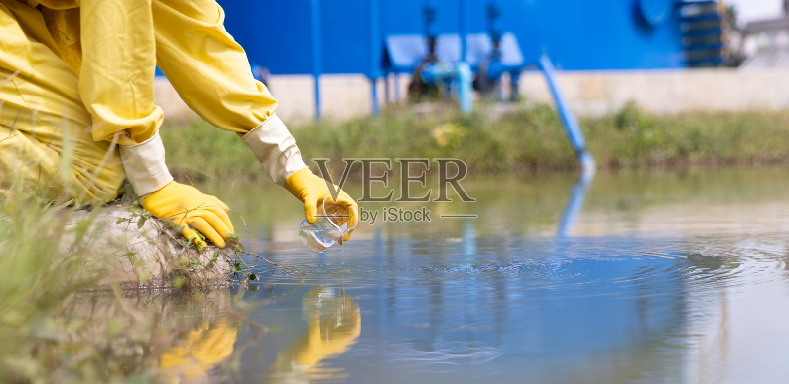 水质控制工作人员和科学家穿着个人防护装备，正在采样水并分析水质，工业与环境。照片摄影图片