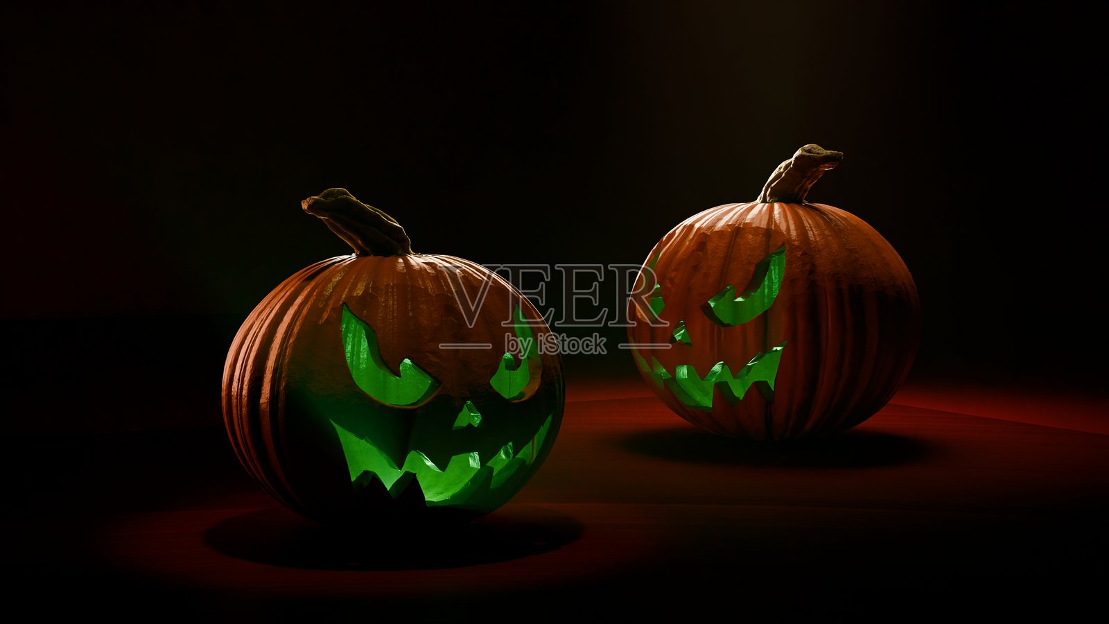 一对发光的万圣节南瓜，戴着女巫帽，置于深红色舞台上照片摄影图片