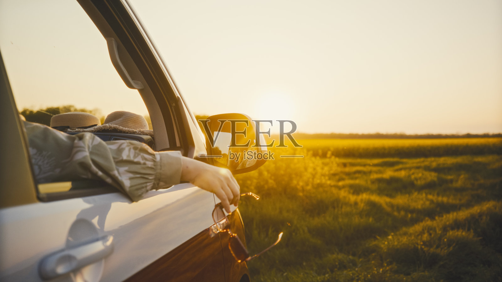 女人在田野中从车窗欣赏日落照片摄影图片