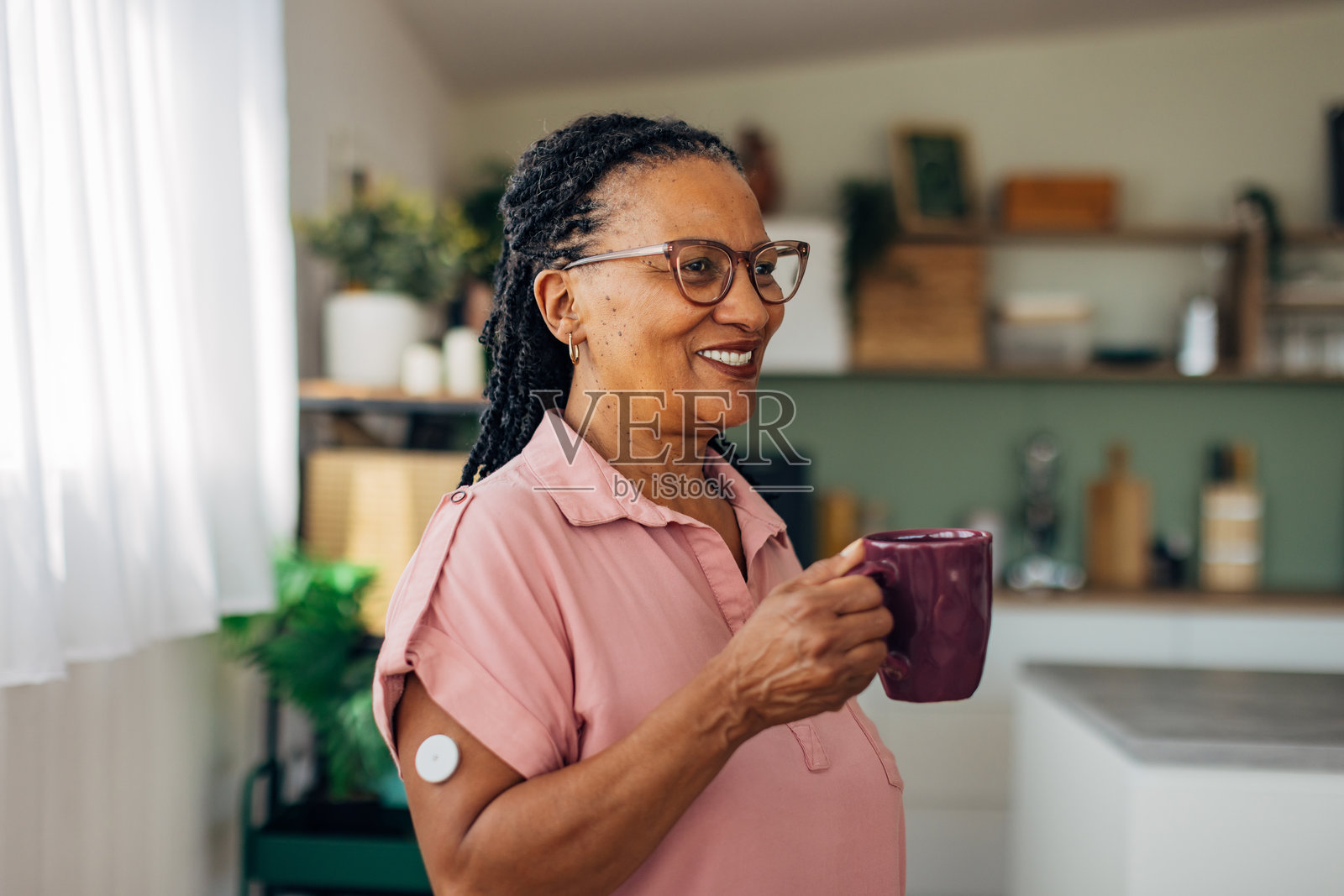 一位患有糖尿病的女性在客厅里站着喝咖啡照片摄影图片