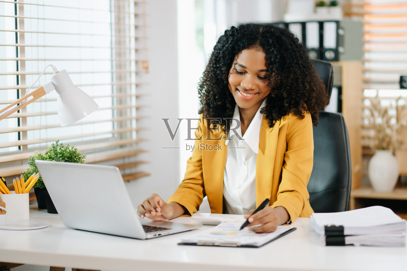 商务女性在办公桌上使用平板电脑和笔记本电脑进行财务数学计算，税务。照片摄影图片