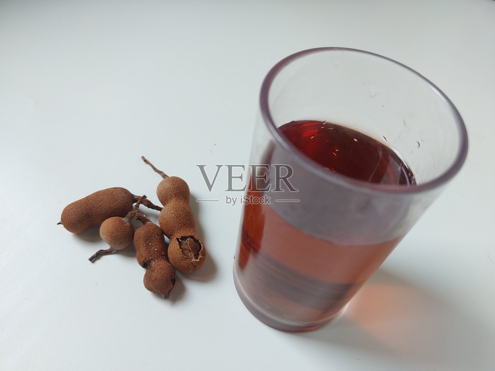 罗望子果和罗望子汁，背景为白色照片摄影图片