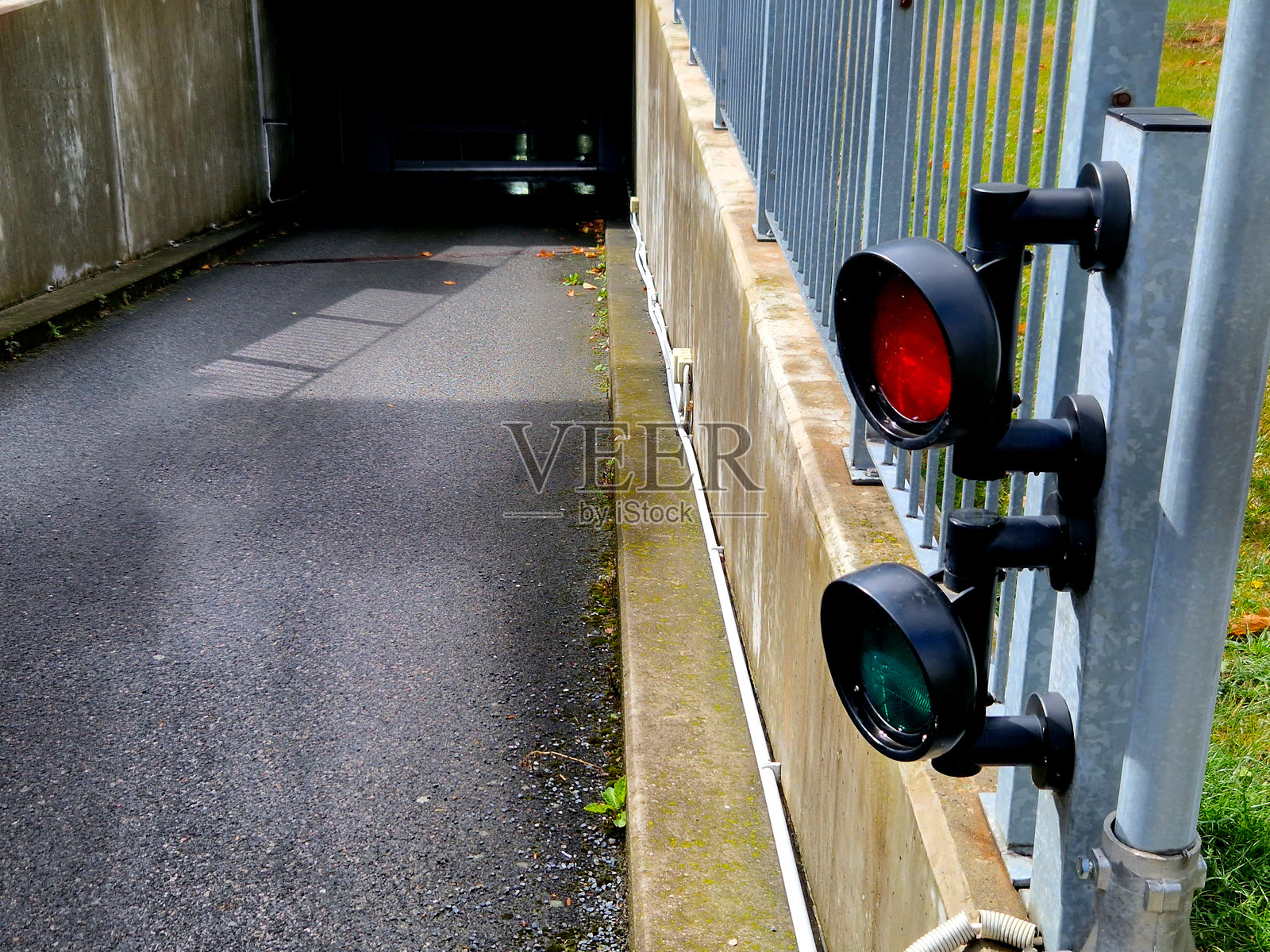 带有两个灯的交通信号灯，安装在金属灰色的车库或仓库外立面上。用于引导卡车进入货物装卸坡道，调节购物中心和院子的车库入口。照片摄影图片