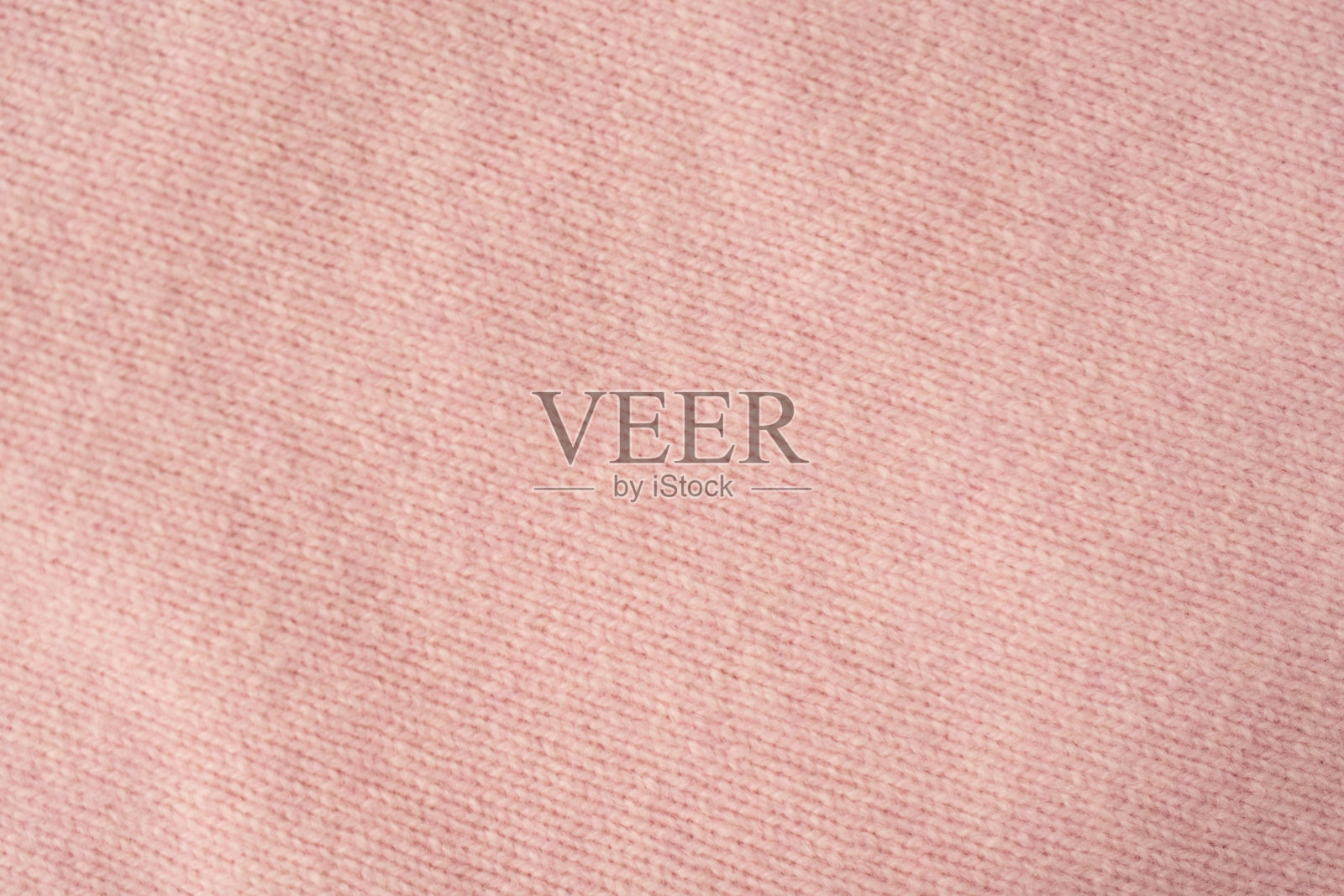 柔和粉色的开司米毛衣纹理背景。照片摄影图片