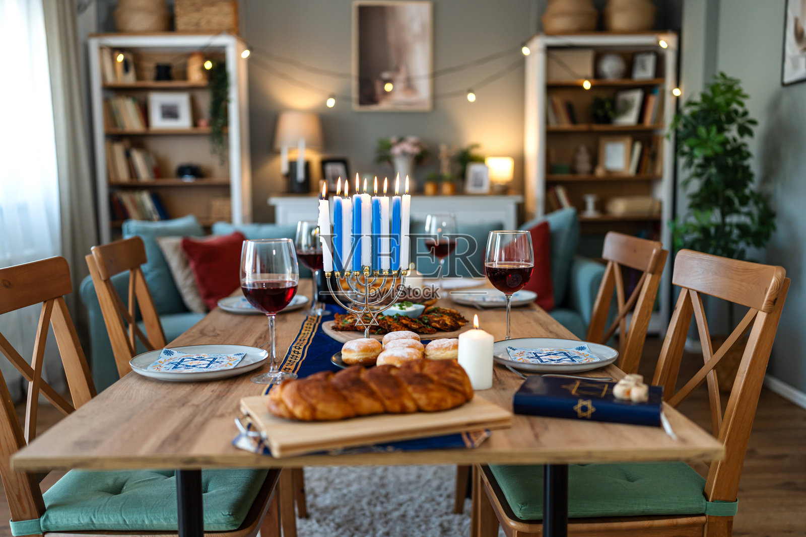 家庭在节日餐桌和烛台旁庆祝光明节照片摄影图片