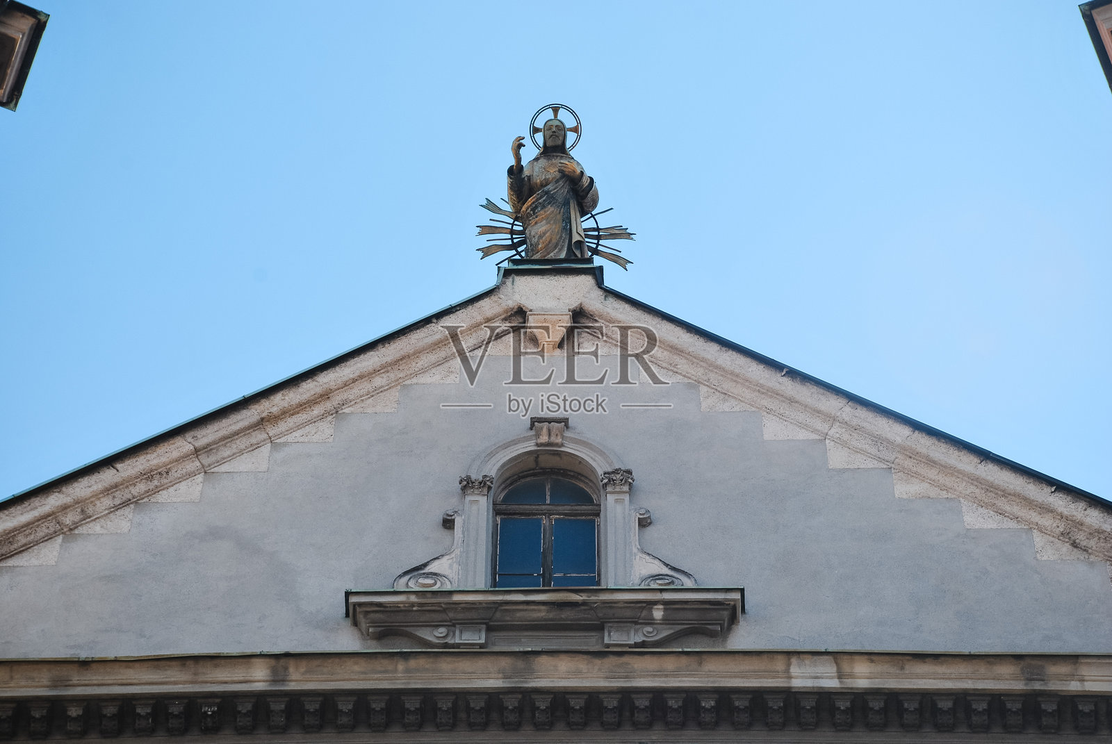 历史悠久的教堂外立面与宗教雕像在晴朗的蓝天下照片摄影图片