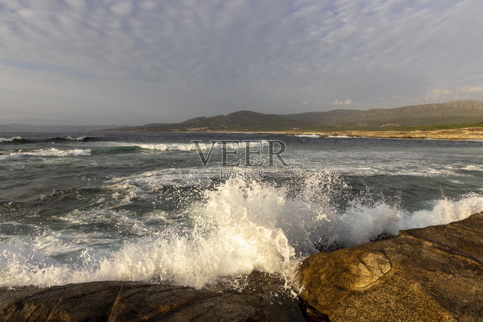 海洋波涛汹涌，浪花拍打着岩石。照片摄影图片