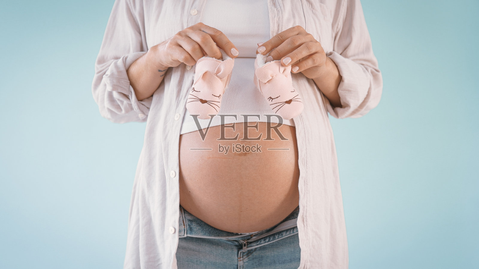 孕妇手握婴儿鞋照片摄影图片