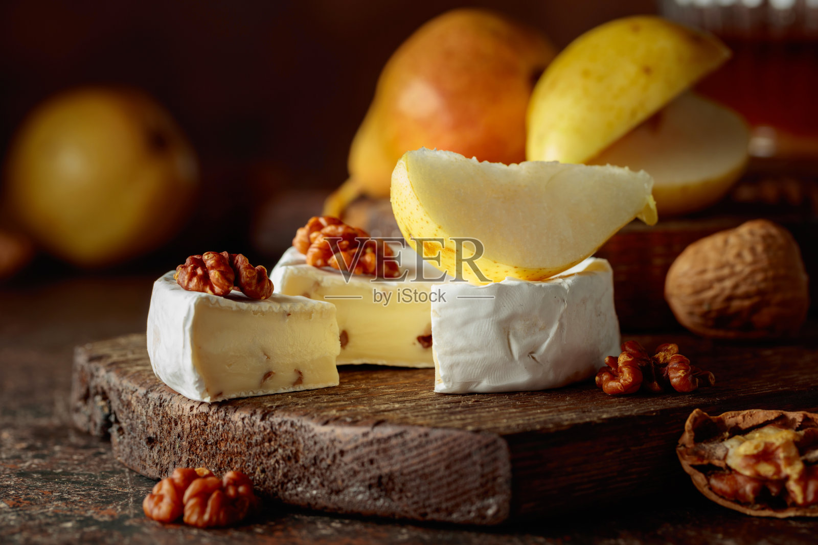 卡门贝尔奶酪配梨、核桃和蜂蜜。照片摄影图片