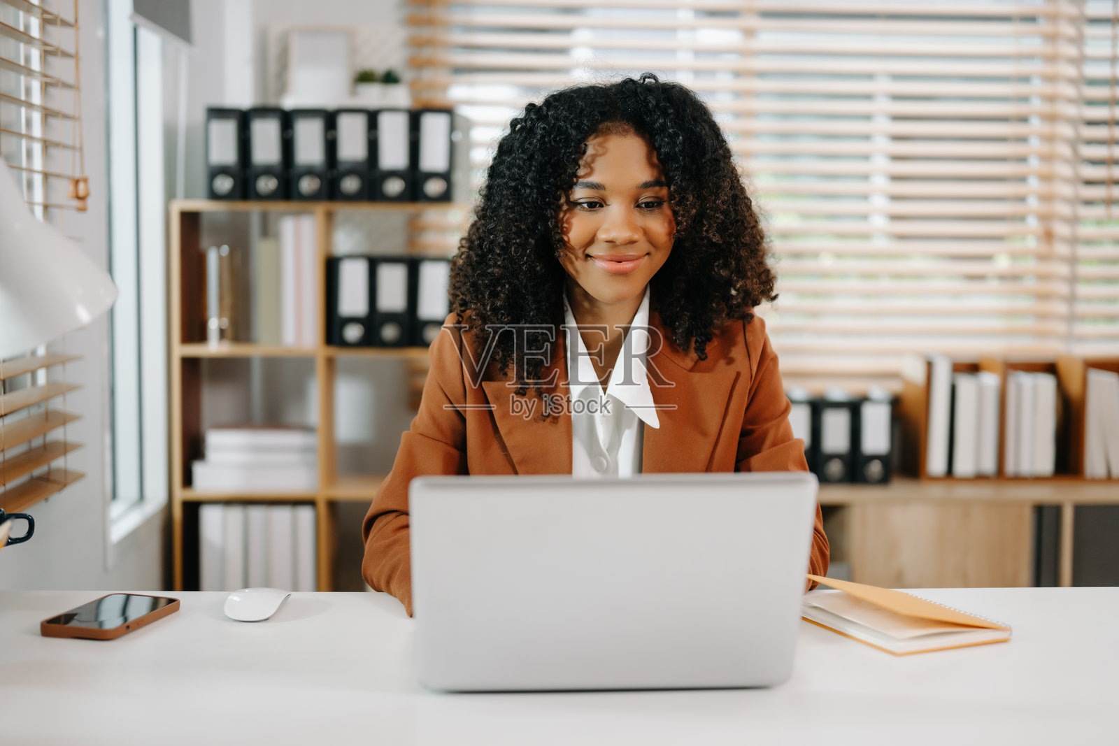 女商人在现代办公室桌上使用平板电脑和笔记本电脑分析财务数据照片摄影图片