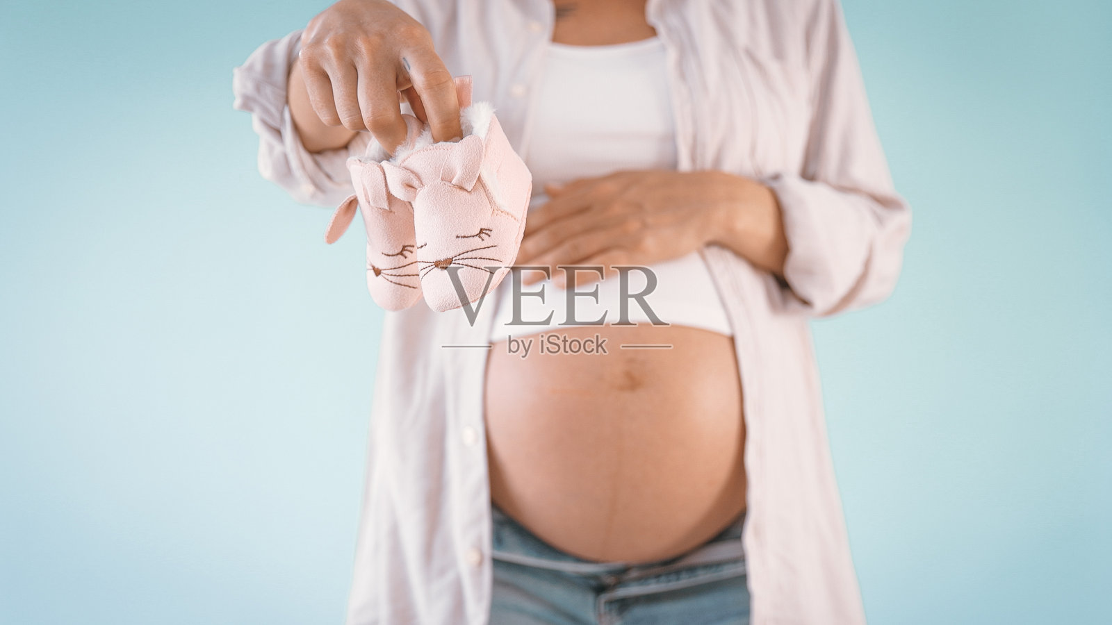 孕妇手握婴儿鞋照片摄影图片