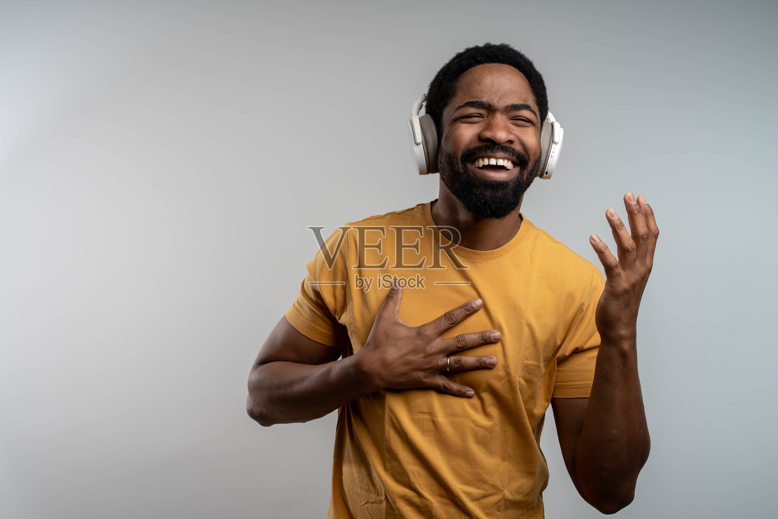 无忧无虑的年轻黑人男孩戴着无线耳机跳舞照片摄影图片