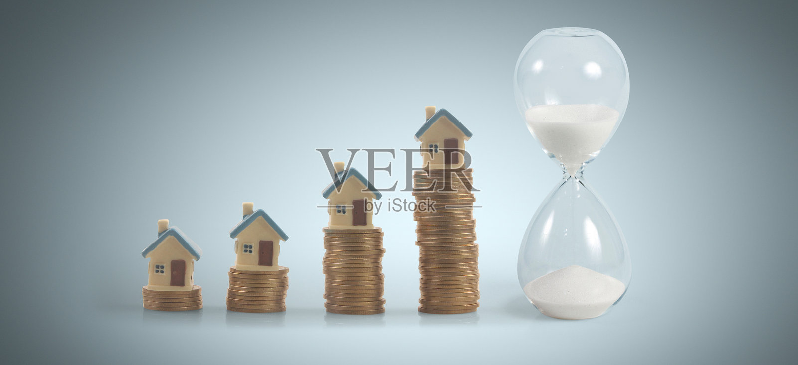 装满沙子的沙漏，象征着时间的流逝和银币的库存。商业概念，以及金融、银行和投资的成功。照片摄影图片