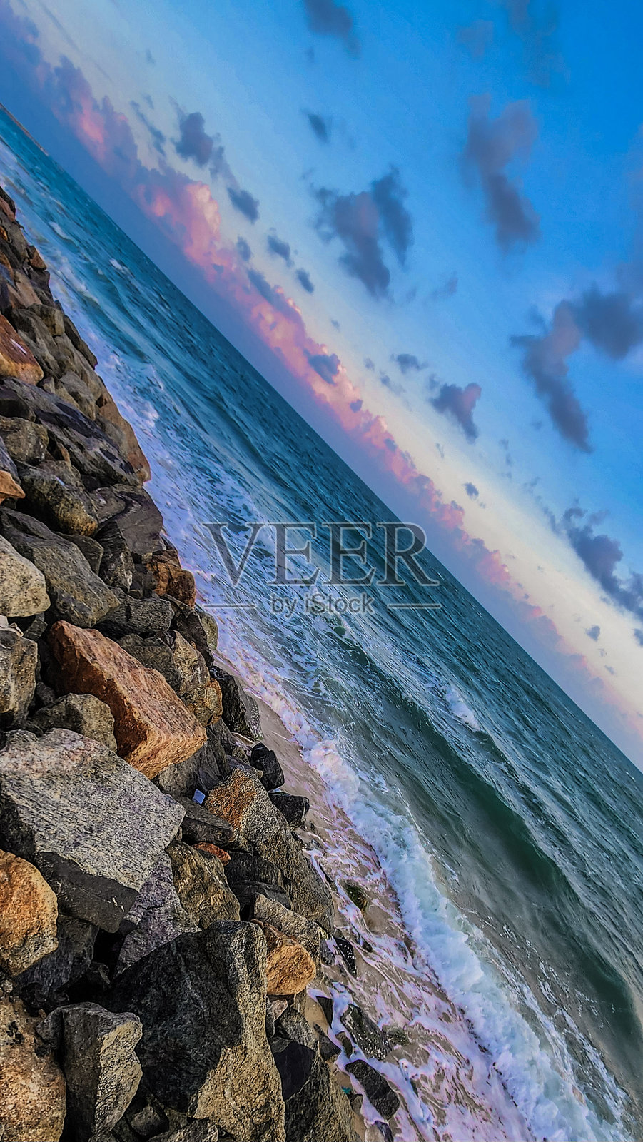 泰米尔纳德邦拉梅什瓦朗的达努什科迪海滩美丽的景色，印度洋的海浪在多云的天空下撞击岩石海岸，色彩斑斓的光线映照其间。照片摄影图片