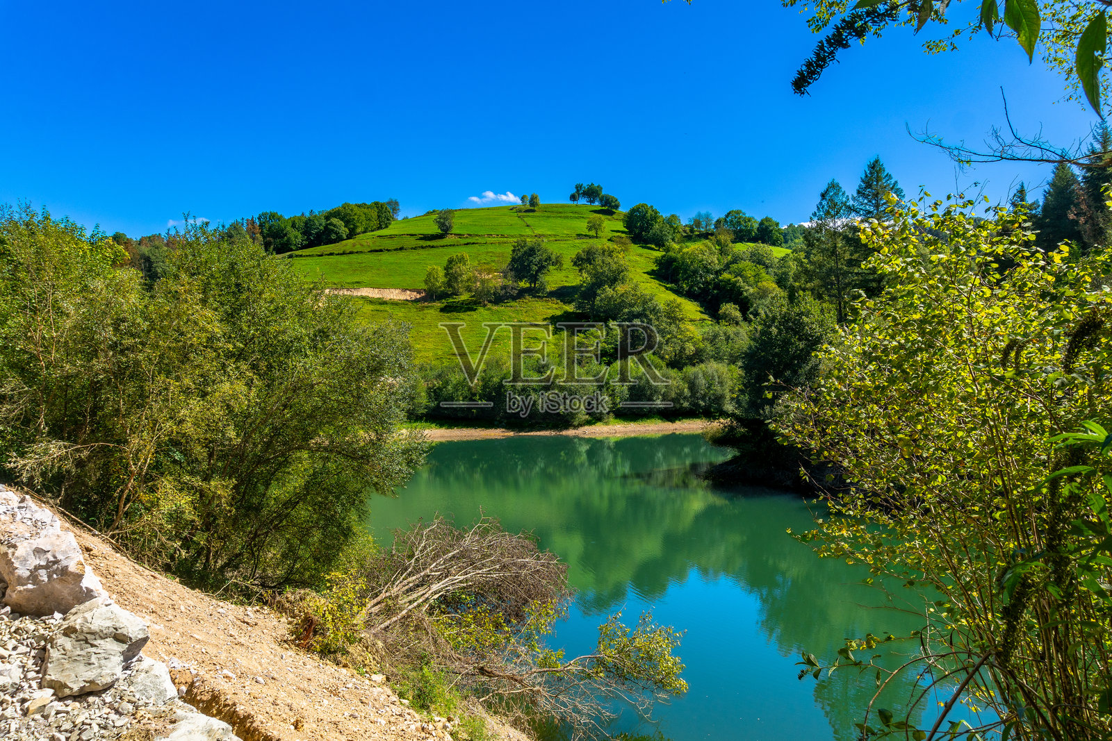 托洛萨的伊比乌尔水库映照出绿色的山丘，巴斯克地区照片摄影图片