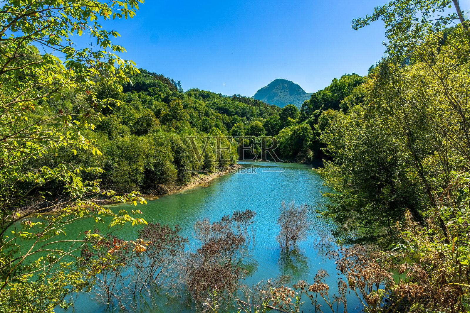 伊比乌尔水库映照着巴斯克地区托洛萨的郁郁葱葱的山丘照片摄影图片