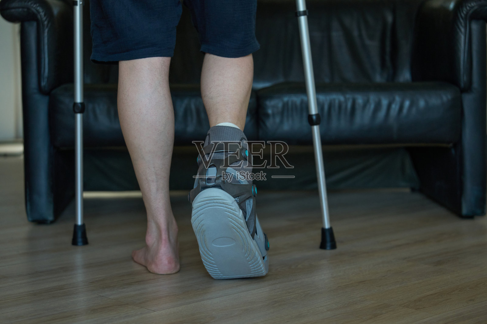 伤后恢复。拐杖和矫形步行靴。照片摄影图片