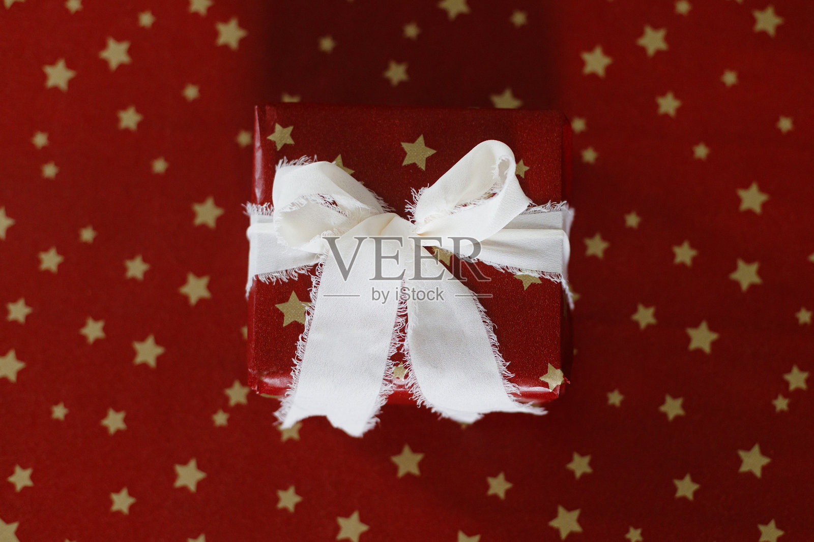 时尚的圣诞礼物平铺在红色纸上。圣诞快乐，节日快乐！红色纸包裹的圣诞礼物配有丝带，留白空间。节日庆祝横幅照片摄影图片