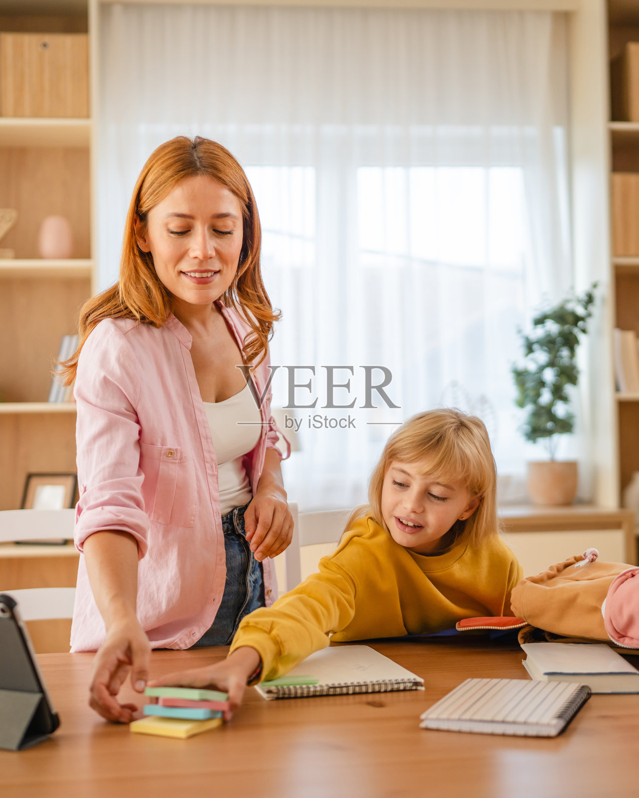 母亲在家帮助女儿准备学习用品照片摄影图片